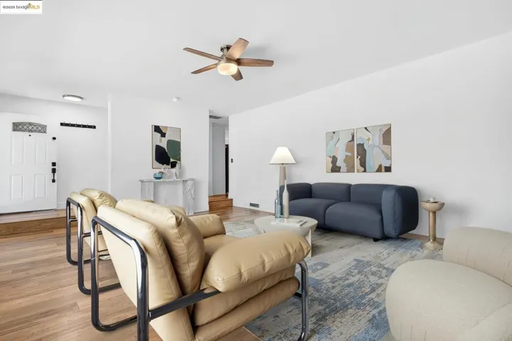 Living room featuring ceiling fan and light wood-style floors