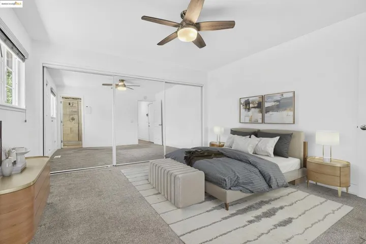 Carpeted bedroom with ceiling fan and a closet