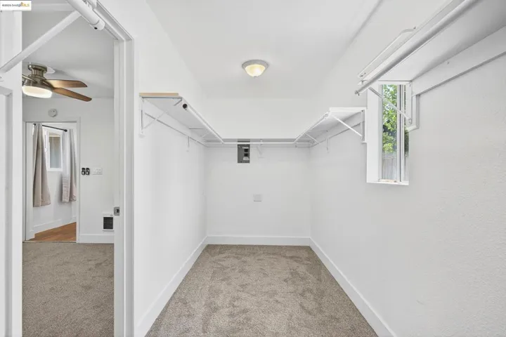Spacious closet featuring carpet flooring and a ceiling fan