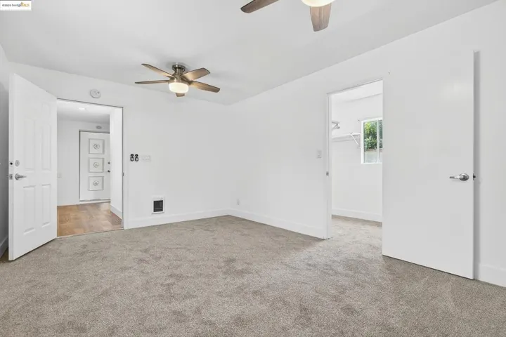 Carpeted spare room with ceiling fan and baseboards