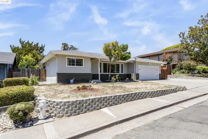 Single story home with an attached garage, concrete driveway, stucco siding, and brick siding