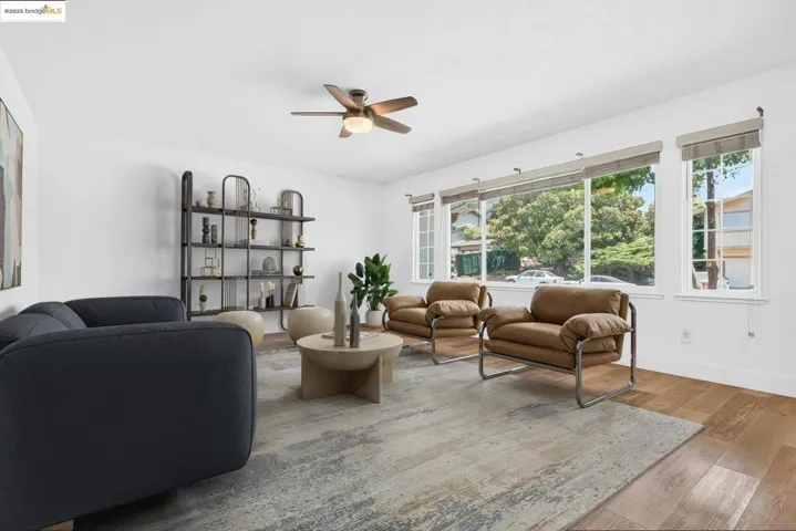 Living area with a ceiling fan and wood finished floors