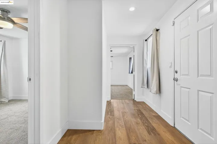 Corridor featuring dark wood-style flooring and baseboards