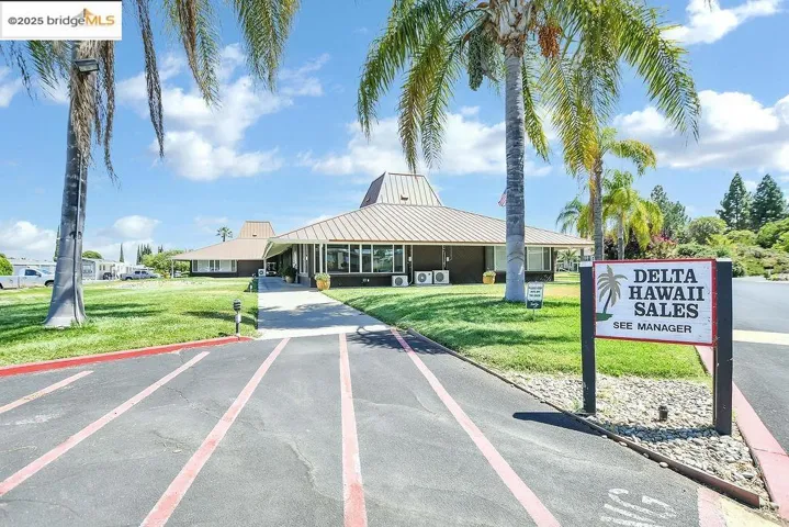 View of home's community with uncovered parking and a yard