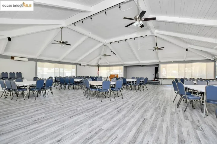Dining area with wood finished floors, rail lighting, and a ceiling fan