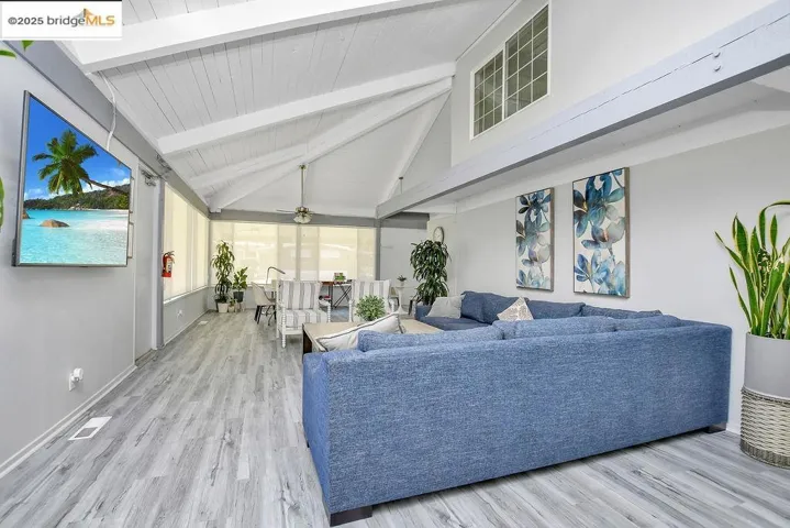 Sunroom / solarium featuring an outdoor hangout area, plenty of natural light, and a ceiling fan