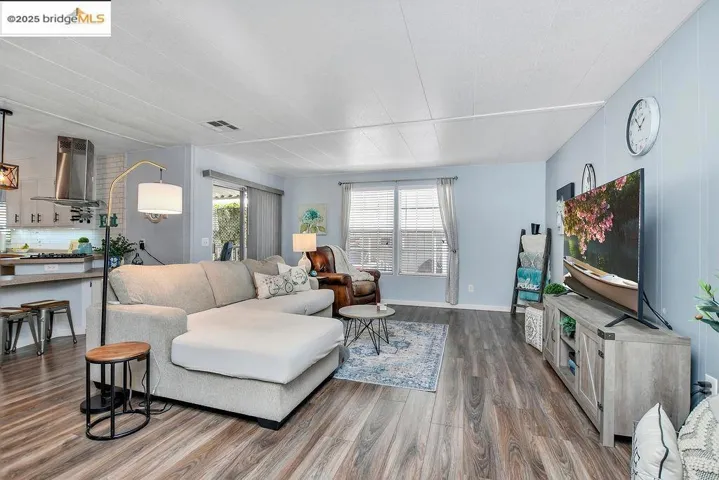 Living area featuring dark wood-style floors and baseboards