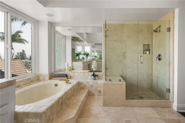 Luxurious Spa-Like Bathroom with Soaking Tub, Walk-In Shower, and Garden Views