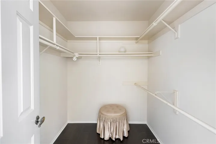 pacious Primary Walk-In Closet with Ample Storage and Built-In Shelving