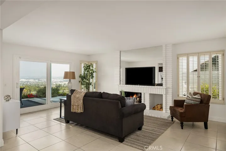 Panoramic Views and Cozy Vibes: Family Room with Fireplace and Patio Access