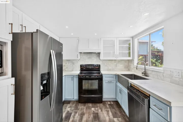 Kitchen featuring appliances with stainless steel finishes, white cabinetry, dark wood-style floors, recessed lighting, and light countertops