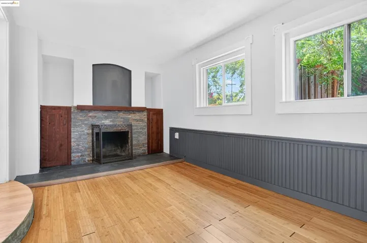 Unfurnished living room featuring wainscoting, a fireplace, and hardwood / wood-style flooring