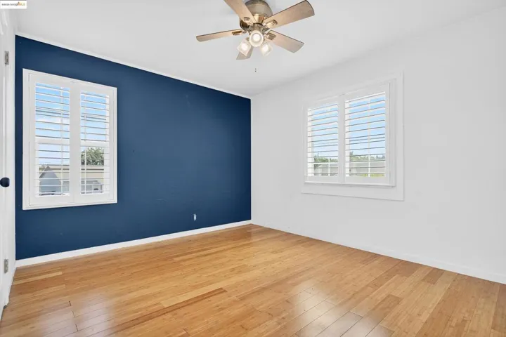 Empty room featuring light wood finished floors and a ceiling fan