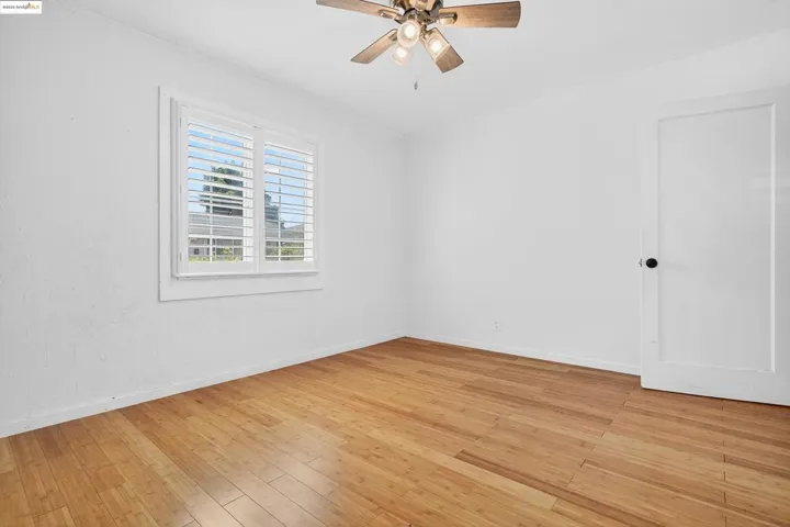 Empty room with light wood-style flooring and ceiling fan