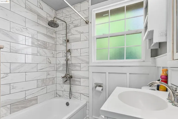Bathroom featuring shower / tub combination and a decorative wall