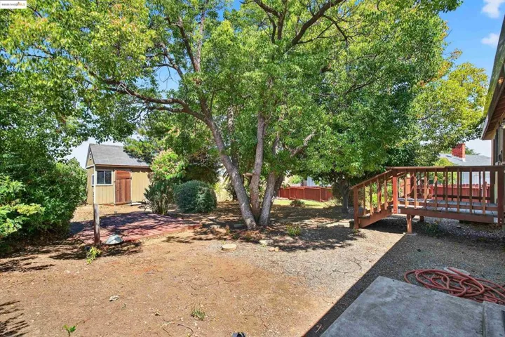 View of yard featuring a deck and a storage unit