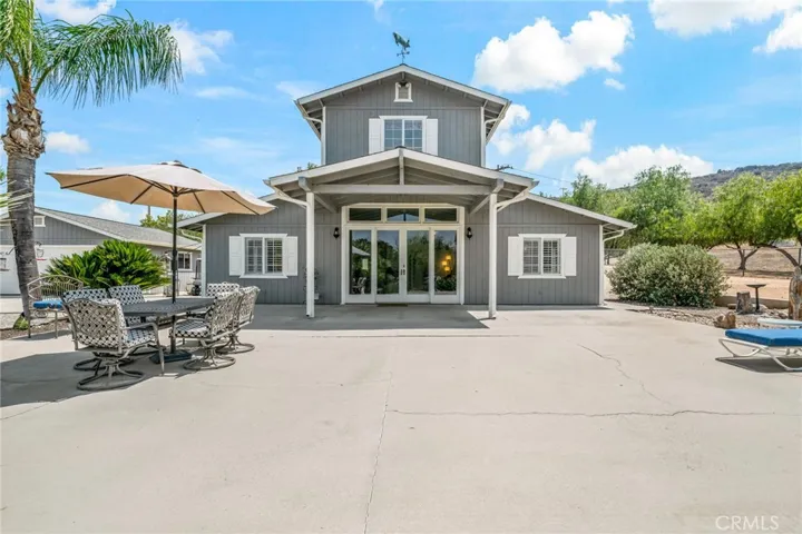Front of house and expansive front porch/patio area for larger gatherings and/or quiet, peaceful evenings to watch the sunset w detached garage to the left