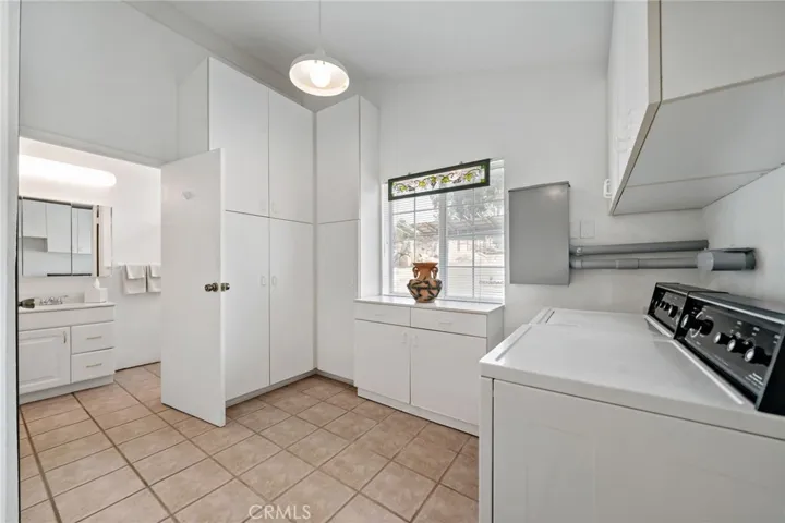 Laundry room w plenty of storage and door leading to 2nd downstairs bathroom.