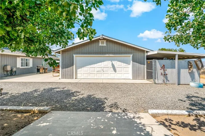 Rear of garage with pull thru door for boats, trailers, etc. Fenced storage area to the right.