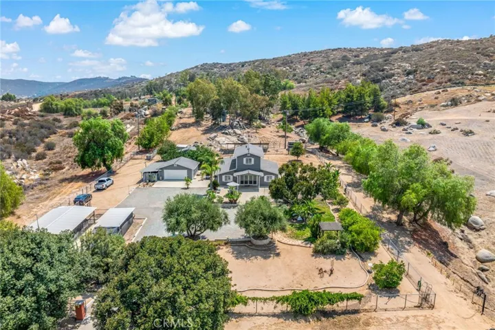 Overview looking south showing an abundant & mature tree population and fenced area around the home.