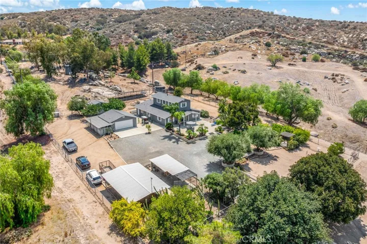 Overview showing main home, detached garage, tool shed behind the garage and chicken coop/dog kennel  in foreground