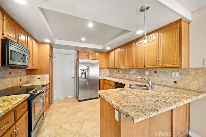 The Upgraded Kitchen Features Granite Countertops, a Breakfast Bar, Recessed Lighting, an Abundance of Cabinetry, Tile Flooring, Electric Range, Dishwasher, and Built-In Microwave.