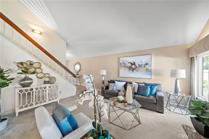 . The Spacious Living Room Boasts 2-Story Soaring Open Beamed Ceiling, Brick Fireplace, and High Transom Windows for Lots of Natural Light.