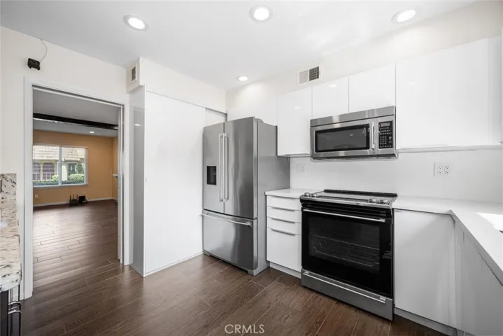 To the left of the refrigerator there is a decent sized pantry for food storage.