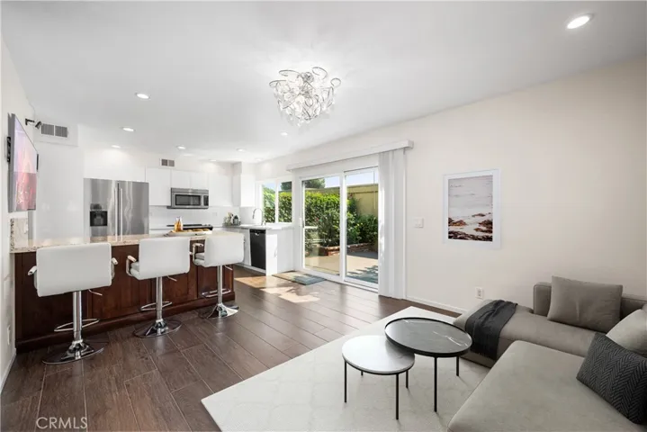 Virtually staged family room opens up to kitchen area. The Peninsula Counter in the kitchen where the 3 barstools are was added at the same time when the Coffee Station was added to the dining room. The Peninsula features a Granite Countertop and lots of additional storage.