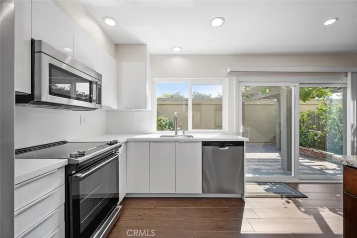 Bright and open concept kitchen with newly installed Milgard windows and sliding glass door.