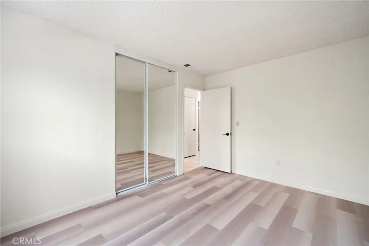 The secondary bedrooms offer wood flooring and mirrored closet doors