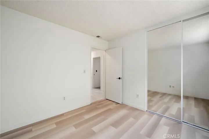 The secondary bedrooms offer wood flooring and mirrored closet doors