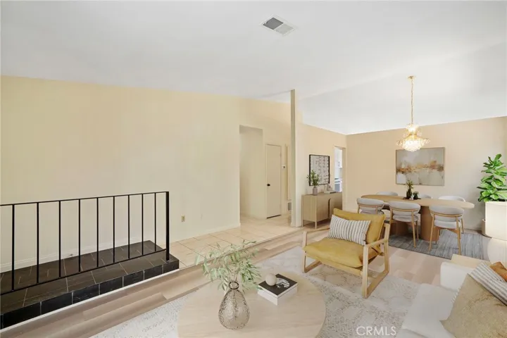 The open floor plan connects the kitchen to the spacious living room with soaring ceilings, smooth-finished ceilings, and a formal dining area.