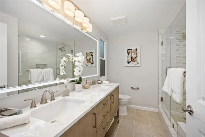 Ensuite bathroom with designer cabinet & elegant glass enclosed walk-in shower with built-in seat