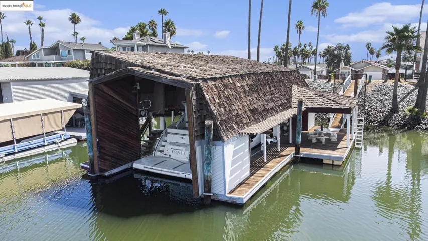 Dock featuring boat lift, a water view, and a residential view