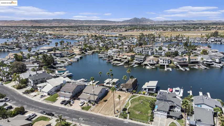Aerial view of property and surrounding area with nearby suburban area and a water and mountain view