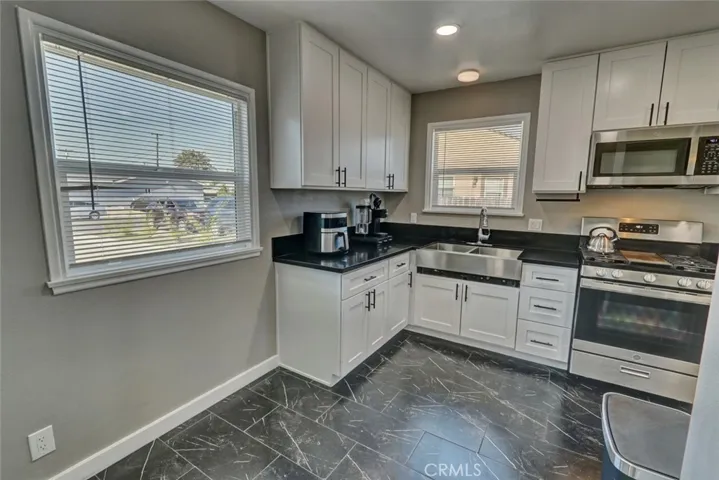 Kitchen upgraded in 2023 with tile floors, granite counters and stainless steel appliances.