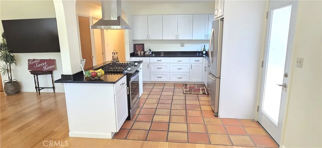 Kitchen has Saltillo tile flooring & a pantry closet.