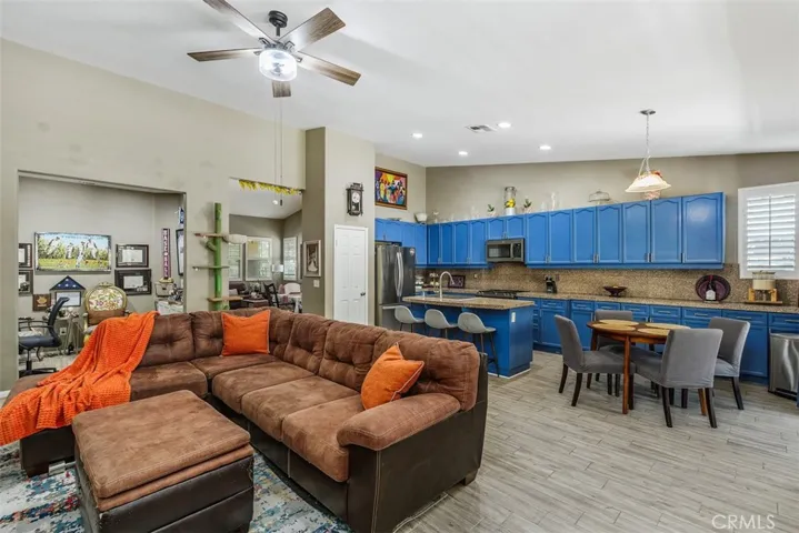 Full view of the family room with ceiling fan, kitchen area, recessed lighting, pantry, and eating space.