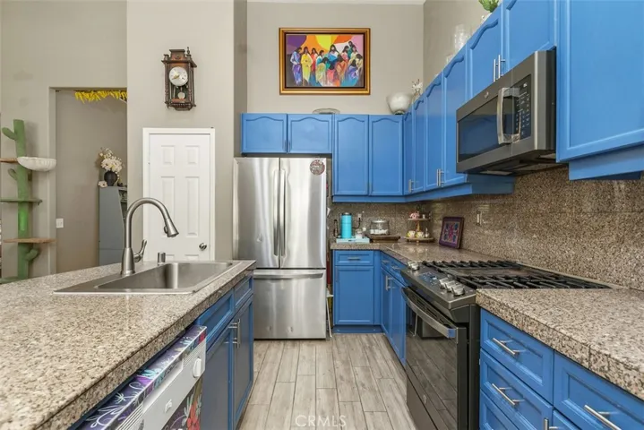 A spacious island featuring a modern sink and faucet, gas cooktop with oven, and built-in microwave above.