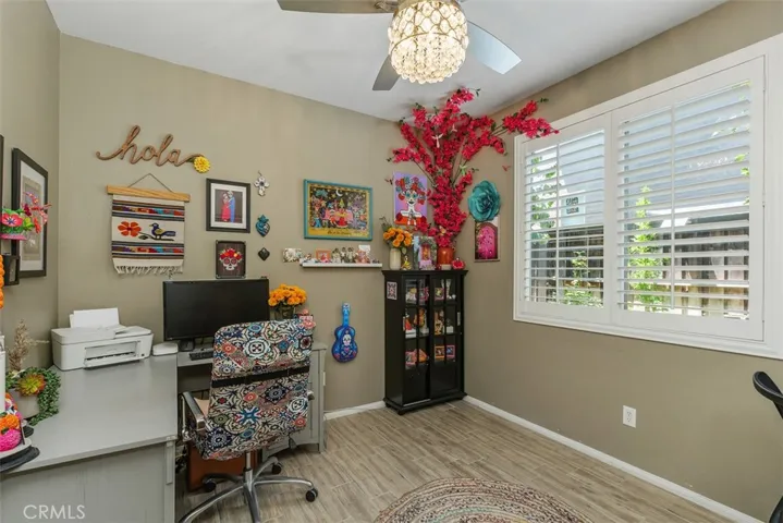 Bedroom 2 features tiled floors and shutters. Ceiling fan with a chandelier.
