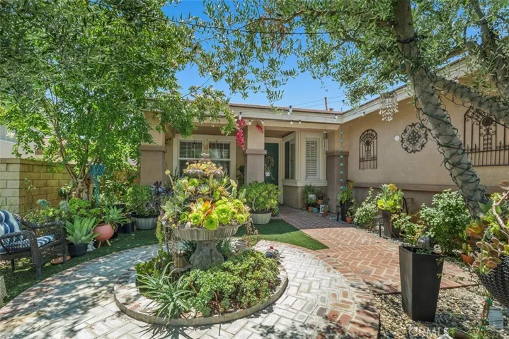 The lush, greenery-filled courtyard with a laid brick entrance.