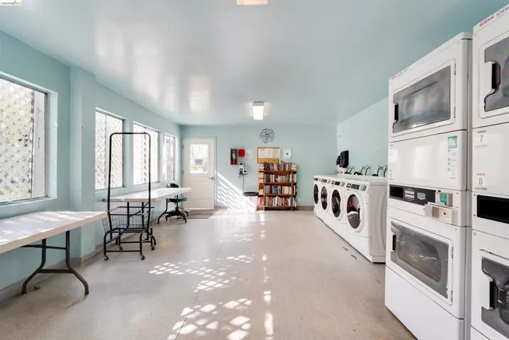 Communal laundry room featuring stacked washer / dryer