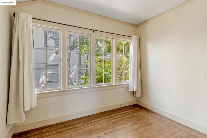Spare room with light wood-type flooring and crown molding