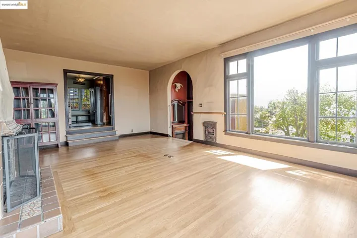 Unfurnished living room with arched walkways and light wood-style flooring