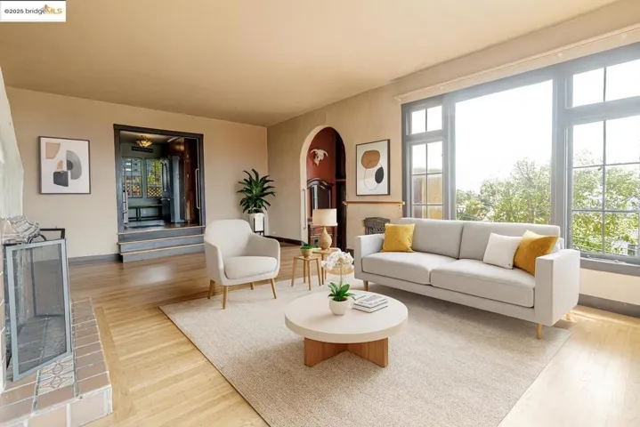 Living room featuring arched walkways, light wood-style floors, and stairs