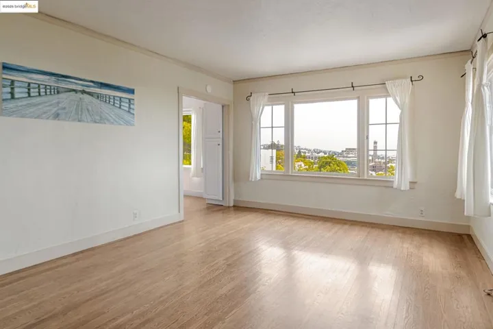 Empty room featuring ornamental molding and light wood-style floors