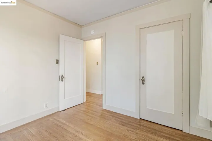 Unfurnished bedroom with light wood-style floors and crown molding