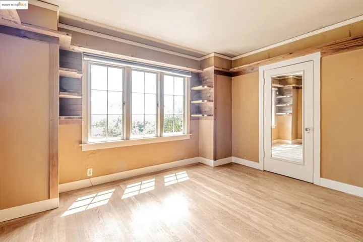 Empty room featuring light wood-style floors and crown molding