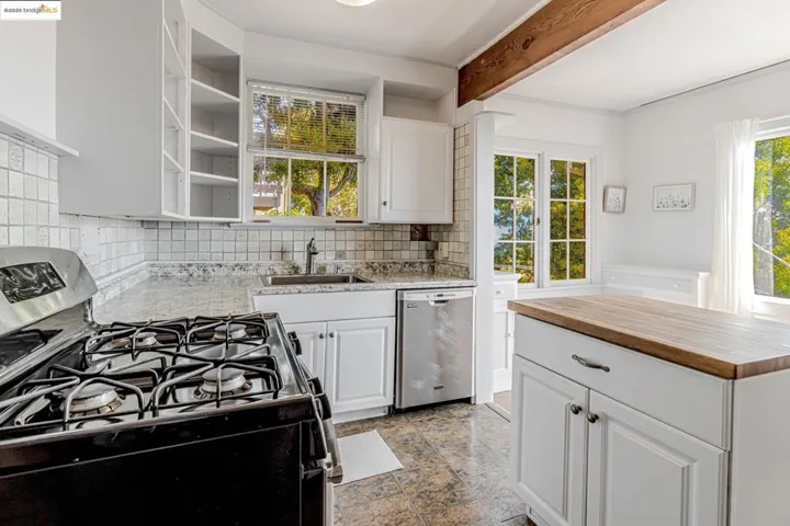 Kitchen featuring wooden counters, white cabinetry, appliances with stainless steel finishes, open shelves, and backsplash